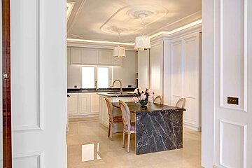 A kitchen with white cabinets and black counter tops