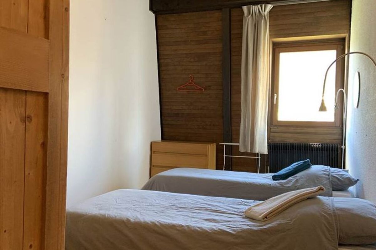 A bedroom with two twin beds and a window