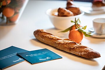 A loaf of bread sits on a table next to a card that says