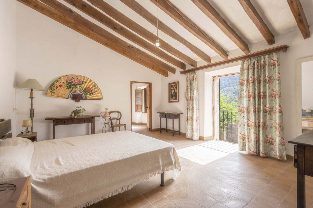 A bedroom with a fan on the wall above the bed