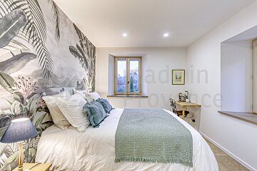 A bedroom with a bed and a window with the words made in provence on the wall