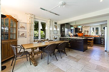 A dining room with a table and chairs and a sign that says immobilier