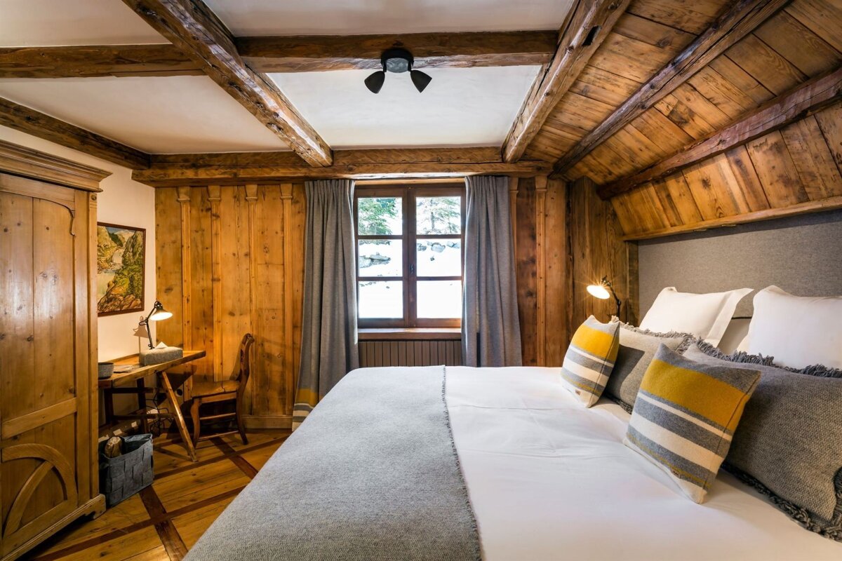 A bedroom with wood paneling and a large bed