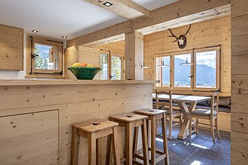 A wooden kitchen with a bowl of fruit on the counter