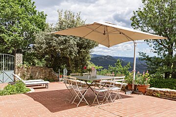 A patio with a table and chairs under an umbrella