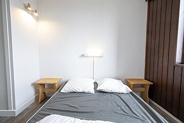 A bed with two pillows on it in a small room