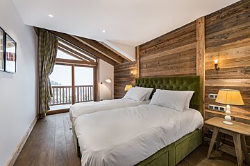A bedroom with two beds and a window