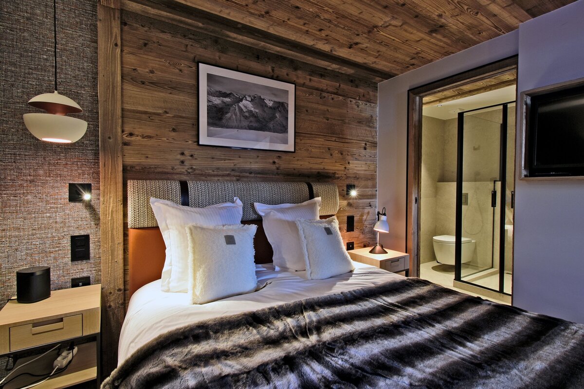 A bedroom with a picture on the wall above the bed