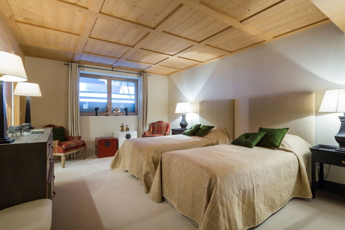 A bedroom with two beds and two lamps