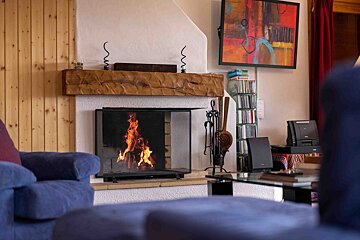 A living room with a fireplace and a painting on the wall