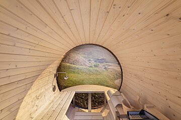 The inside of a wooden sauna with a view of the mountains