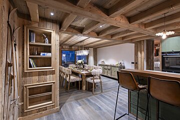 A wooden dining room with a table and chairs