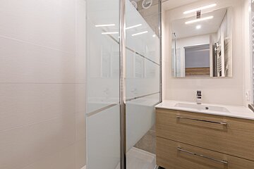 A bathroom with a sink and a walk in shower