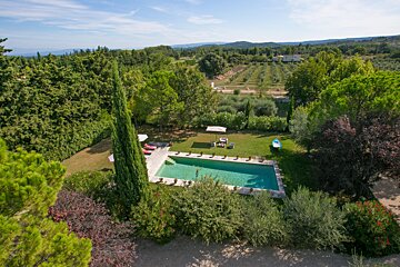 An aerial view of a large swimming pool surrounded by trees