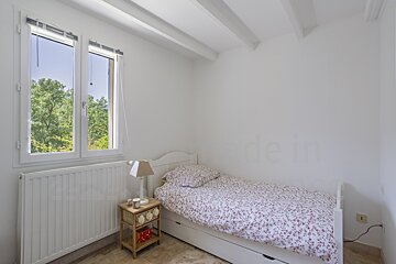 A bedroom with a single bed and a window