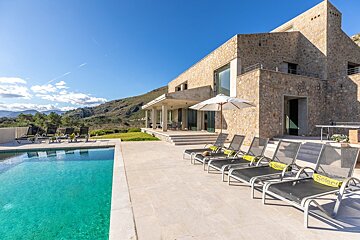 A large stone building with a swimming pool in front of it