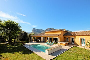A house with a large swimming pool in front of it