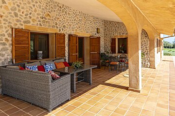 A patio with wicker furniture and a table and chairs