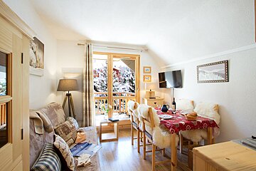 A living room with a couch and a table and chairs