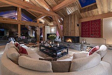 A living room with a round couch and a fireplace