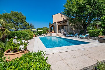 A large swimming pool with a house in the background