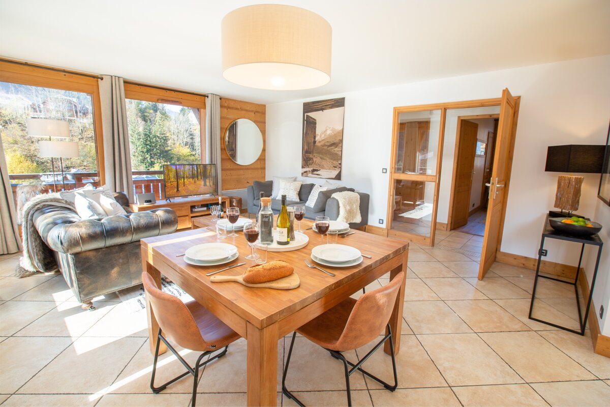A dining table with a bottle of wine on it
