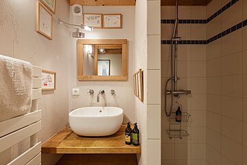A bathroom with a sink a mirror and a shower