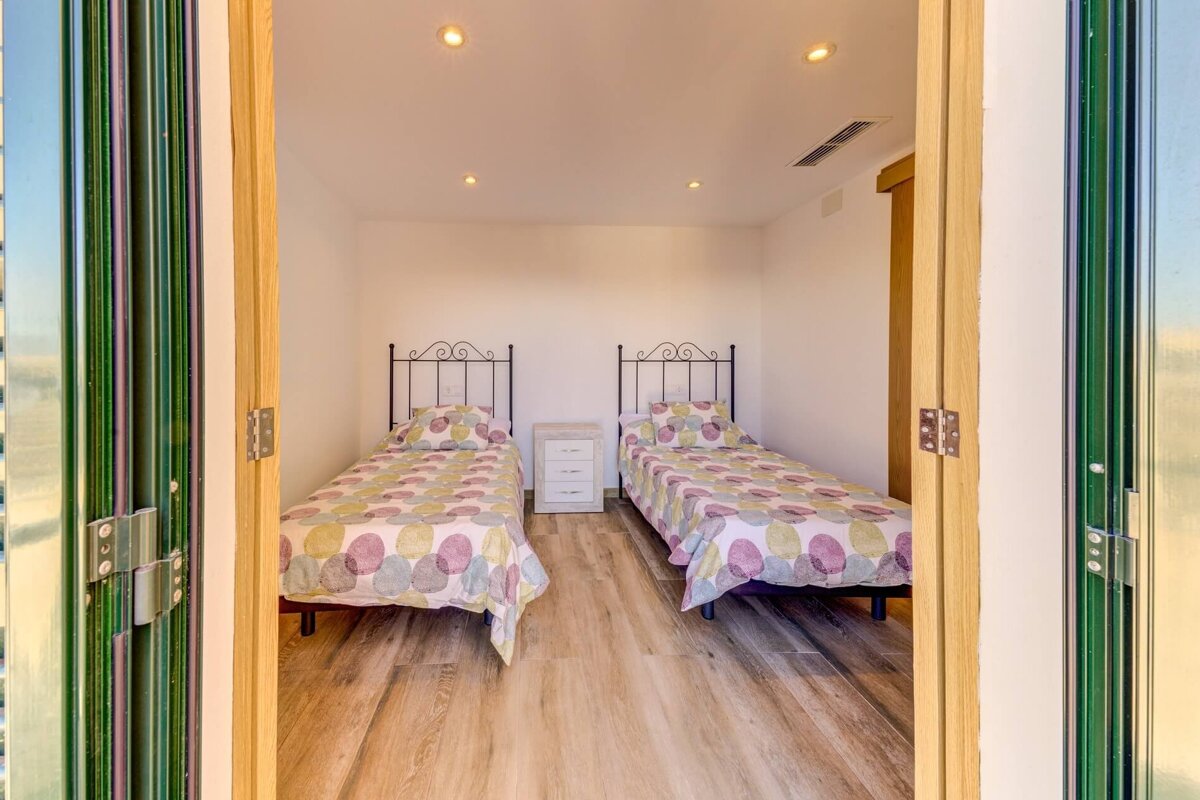 A bedroom with two twin beds and a nightstand