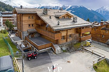 A red atv is parked in front of a building that says vip
