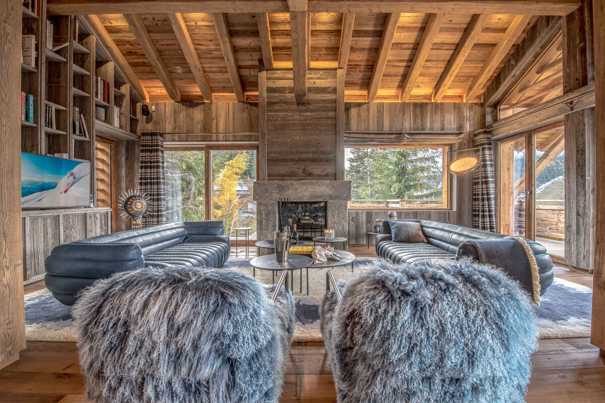 A living room with furry chairs and a fireplace