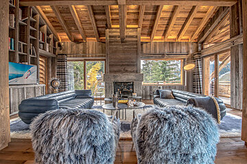A living room with furry chairs and a fireplace