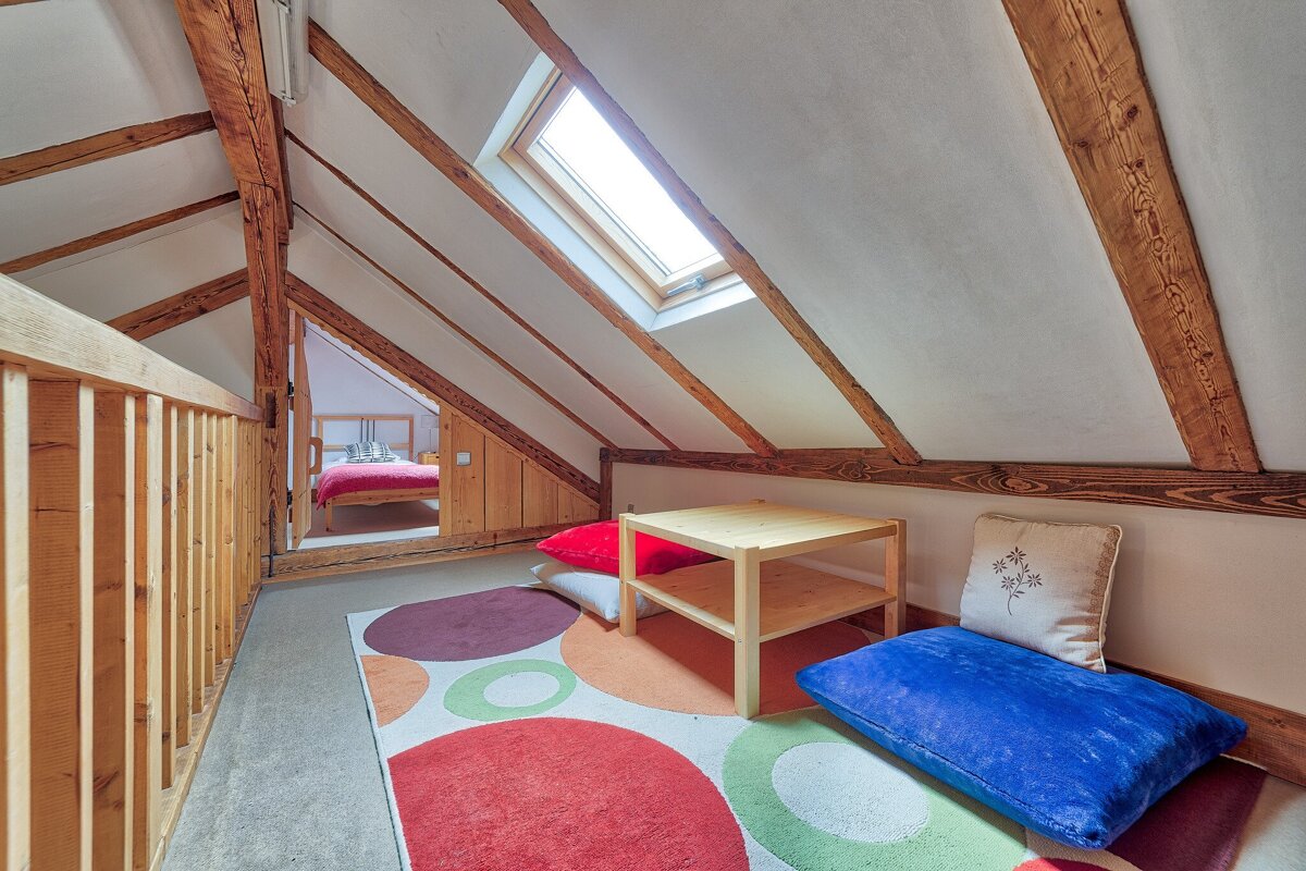 A blue pillow sits on the floor in an attic