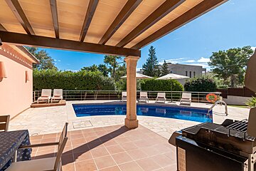 A large swimming pool is surrounded by chairs and umbrellas