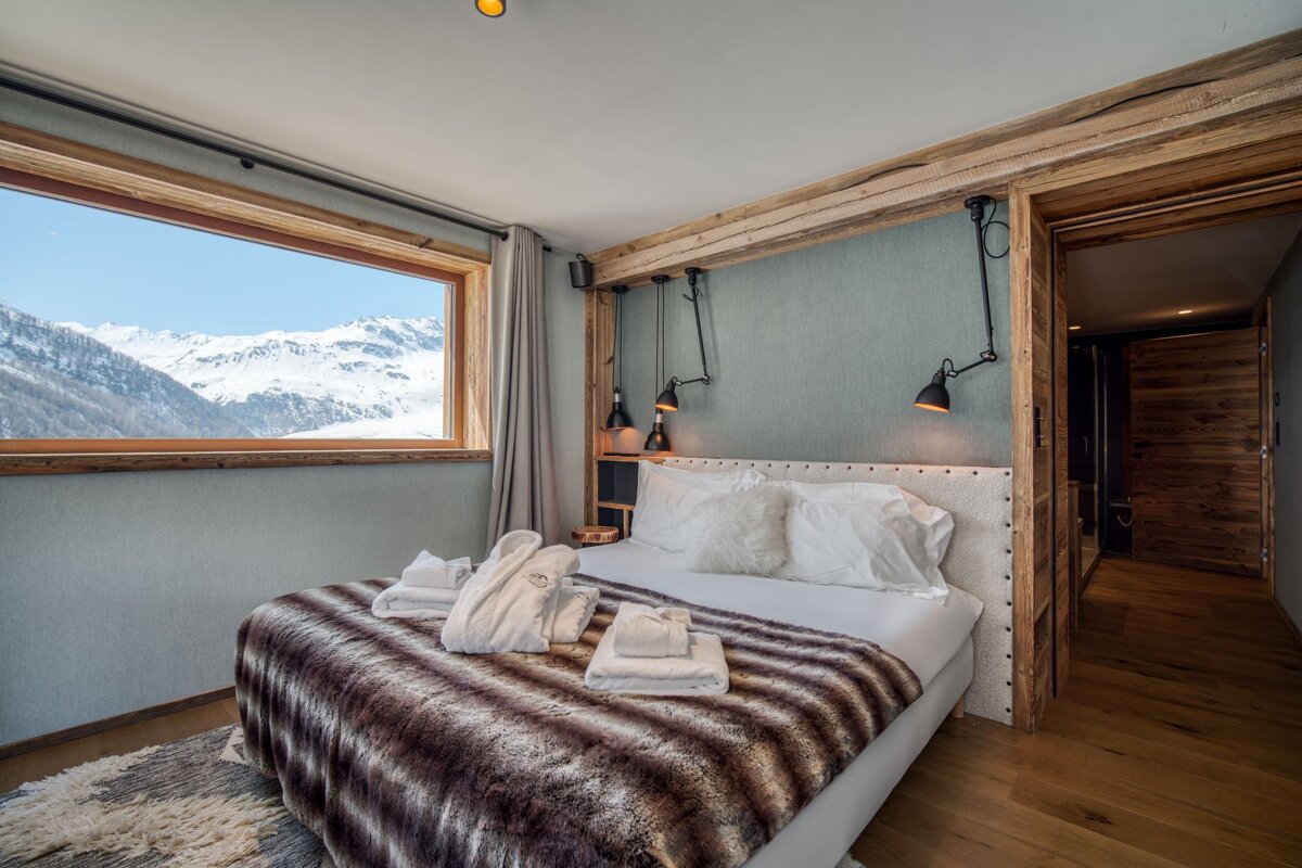 A bedroom with a bed and a blue wall