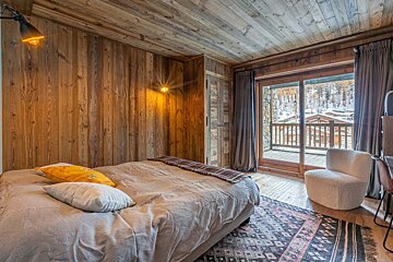 A bedroom with a green blanket on the bed