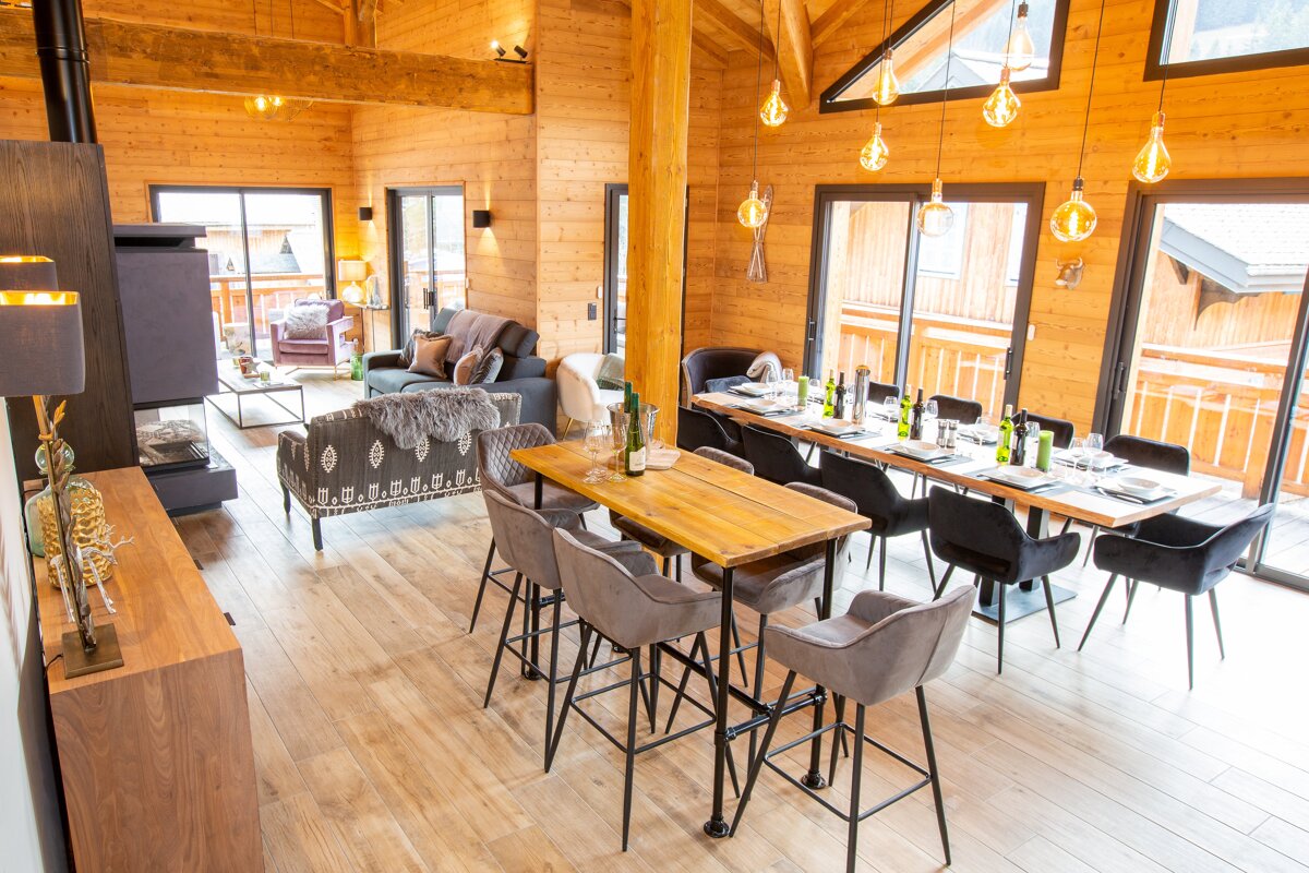 A dining room table with a bottle of wine on it