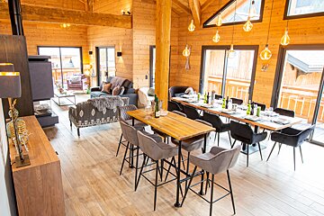 A dining room table with a bottle of wine on it