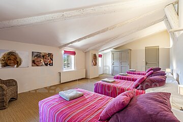 A bedroom with three beds and a picture of a child on the wall