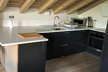 A kitchen with a wooden ceiling and black cabinets