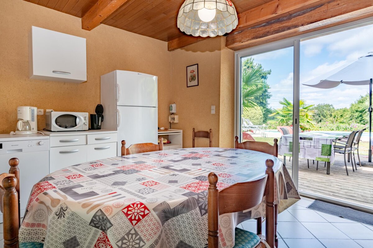 A kitchen with a table and chairs and a sliding glass door