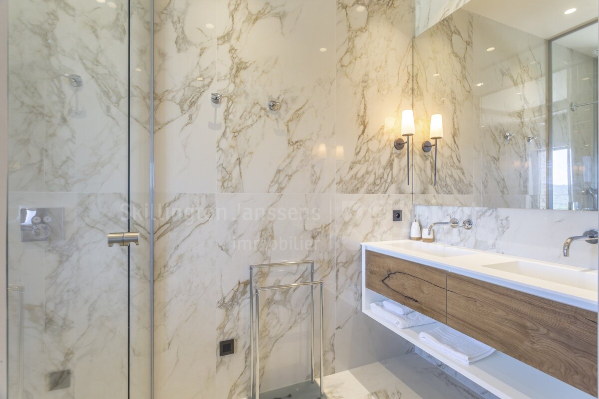 A bathroom with marble walls and a towel rack
