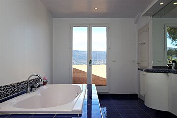 A bathroom with a white tub and blue tiles