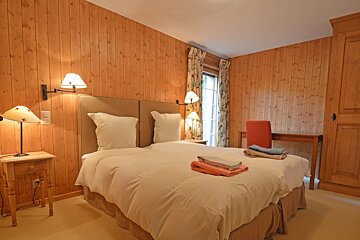 A bedroom with wood paneled walls and two beds