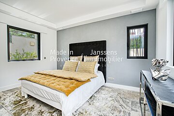 A bedroom with a bed and a window that says made in janssens provence immobilier