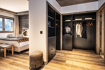 A bedroom with a bed and a walk in closet