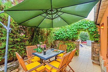 A table with a bottle of wine on it under an umbrella