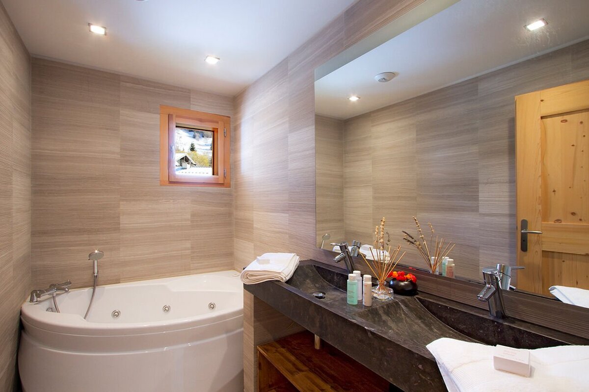 A bathroom with a jacuzzi tub and a large mirror