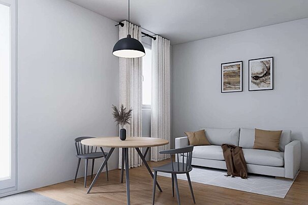A modern, minimalist living/dining room with a light gray sofa, round wooden table, and a black pendant light. Features abstract art and light curtains.