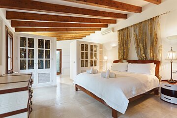 A bedroom with a large bed and wooden beams
