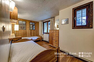 A bedroom with two beds and a knight frank logo